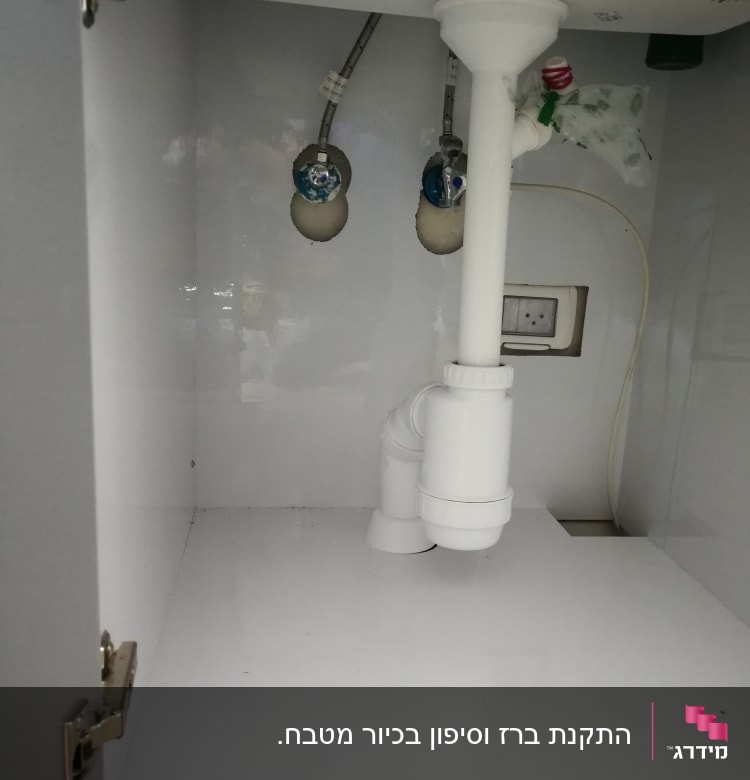 צנרת לבנה מתחת לכיור עם חיבורים